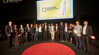 Foto von der Preisverleihung des BADAP 2019. Mehrere Personen stehen auf einer Bühne im Halbkreis. 