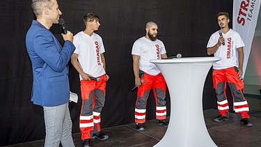 Das Bild zeigt vier Personen rund um einen Stehtisch