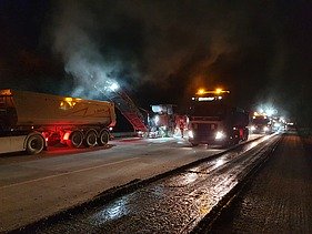 Foto zeigt Fräsarbeiten bei Nacht mit zwei Maschinen und mehreren Fahrzeugen