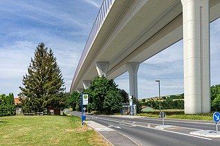 Photo of a new valley bridge seen from below, next to a country road