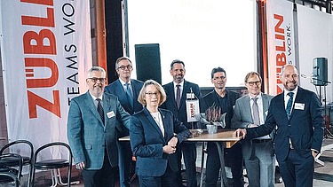 Foto von mehreren glücklich schauenden Personen bei der Jubiläumsfeier am Standort Sande.