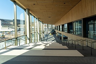 Bild von einem Innenraum, links eine Glasfront, durch die die Sonne scheint