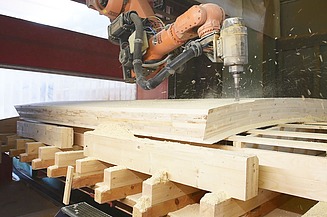 Foto beim bearbeiten von Holz mit einer Industriebohrmaschine.  