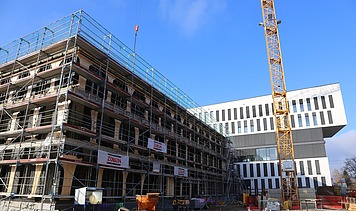 Foto vom Bau eines Hauses. An der Seite ist ein Karan zusehen. 