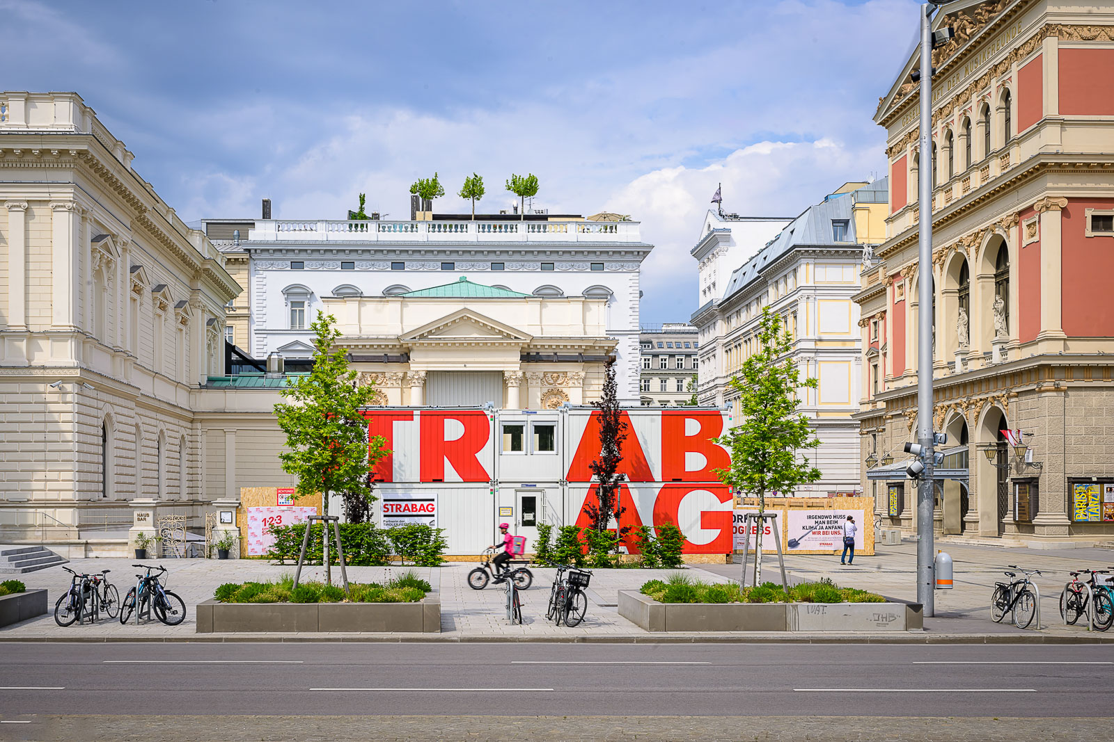 Foto von mehreren STRABAG Containern, die zwischen zwei historischen Gebäuden stehen
