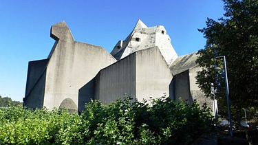 Foto von einer Kirche, drumherum sind Bäume.  