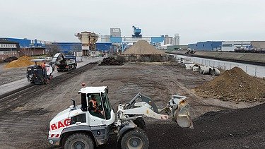 Photo from a bird's eye view. Two construction machines can be seen.