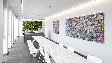 Foto einer Teeküche mit bunten Bildern an der Wand.