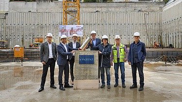 Foto von mehreren Männern bei der Grundsteinlegung. 