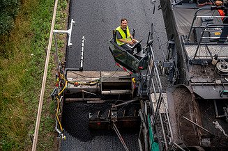 Das Bild zeigt die Praxiserprobung der Robot - Straßenbau 4.0 Maschine auf einer frisch asphaltierten Straße
