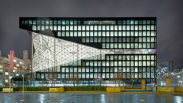 Foto von einem Bürogebäude von außen bei Nacht.  