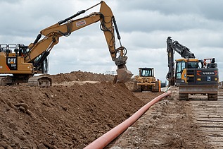 Photo of three working machines on a construction site.   