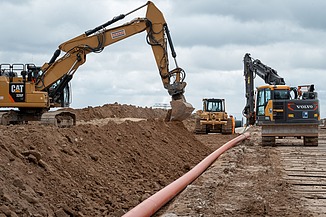 Photo of three working machines on a construction site.   