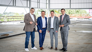 Foto von vier Personen, die in einer Halle stehen