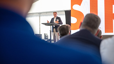 Mann auf einer Bühne spricht