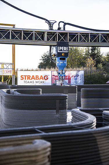 Foto eines 3D Druckers, der eine Mauer druckt 