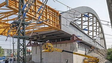 Foto vom Bau einer Brücke über Schienen. 