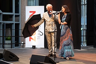 Foto von zwei Personen auf der Bühne. 