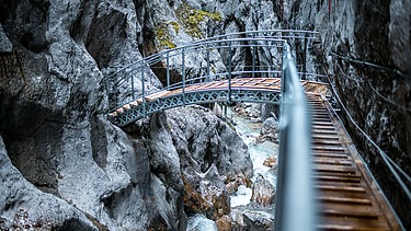 Foto von einer Brücke die durch eine Schlucht führt.  