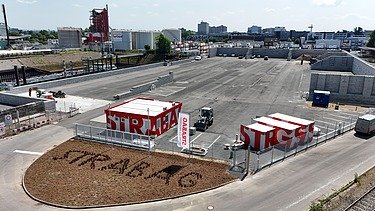 Hof auf dem Baumaschinen stehen und alten Bodenbelag zerkleinern