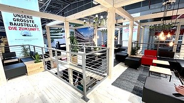 Foto von einem Messestand von STRABAG. Zu sehen ist eine Sitzecke.    