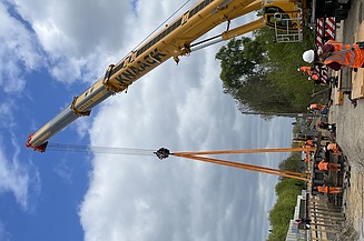 Foto von einer Baustelle mit mehren Personen in Schutzausrüstung. 
