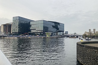 Foto von der „ODE“ in Amsterdam, mit Blick über einen Fluss.   