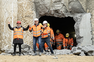 Nahaufnahme von mehren Personen in Schutzausrüstung beim feierlichen Durchschlag zur Wendlinger Kurve.