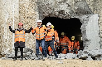 Nahaufnahme von mehren Personen in Schutzausrüstung beim feierlichen Durchschlag zur Wendlinger Kurve.