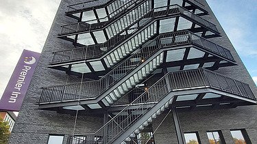 Foto von der Außenwand eines Hotels mit Blick auf die Feuerleiter.