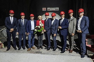 Foto von mehreren Personen mit roten Helmen in einem Tunnel