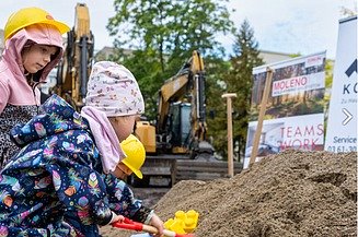 Foto von Kindern die eine Schaufel in die Erde stecken. 