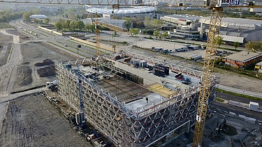Foto einer Baustelle mit einem gelben Kran auf der rechten Seite