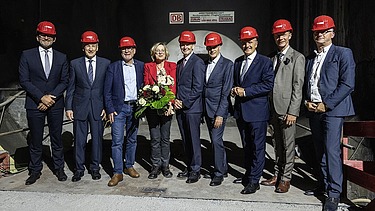Foto von mehreren Personen mit roten Helmen in einem Tunnel