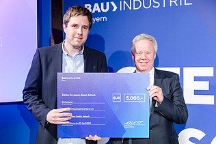 Foto von zwei lächelnden Personen die den Innovationspreis 2022 halten. 