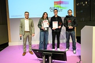 Foto von vier Personen auf einer Bühne. 