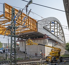 Foto vom Bau einer Brücke über Schienen. 