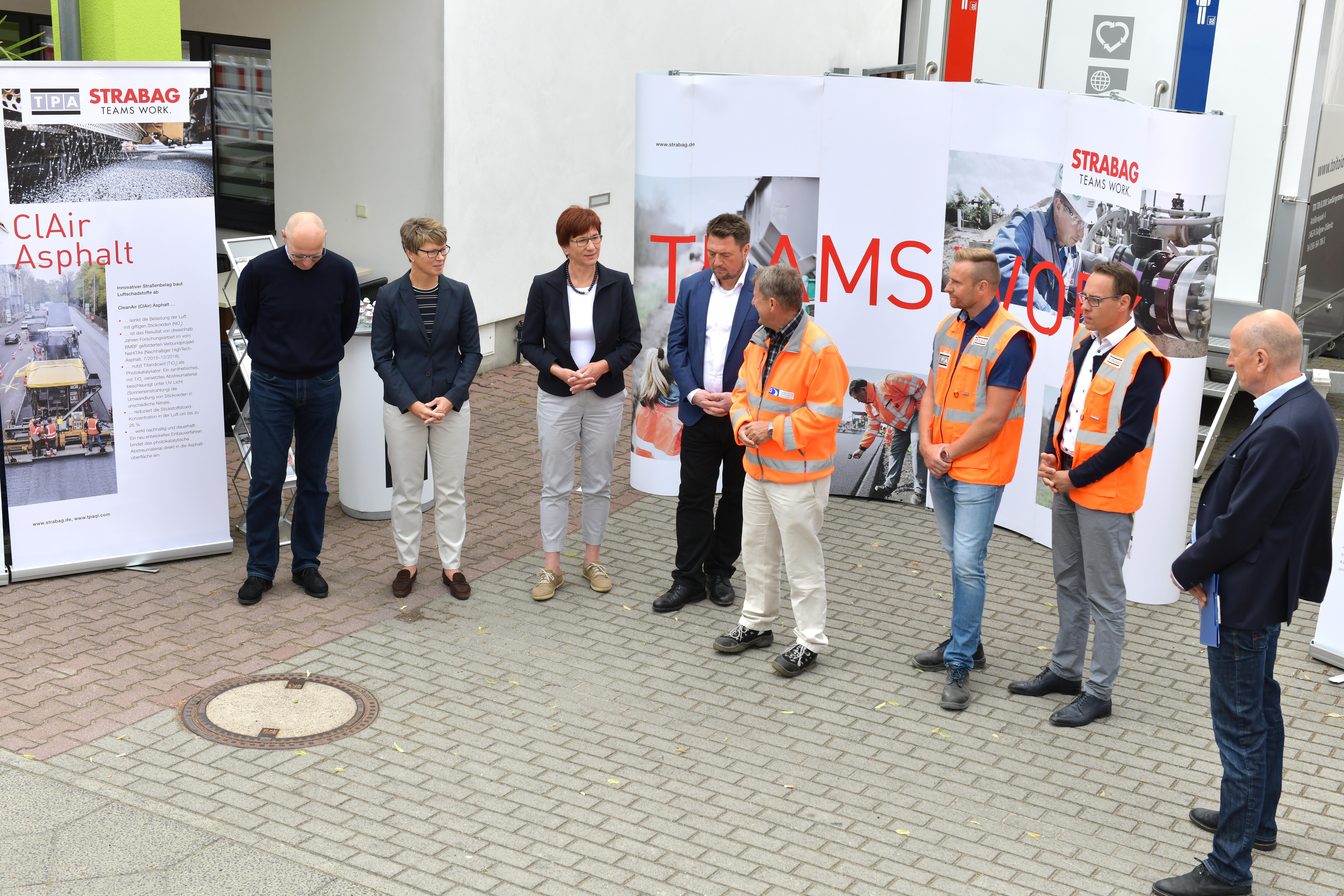 Foto von mehreren Personen, die vor einem Plakat stehen