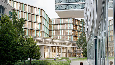 The picture shows an office building with a person and a bicycle