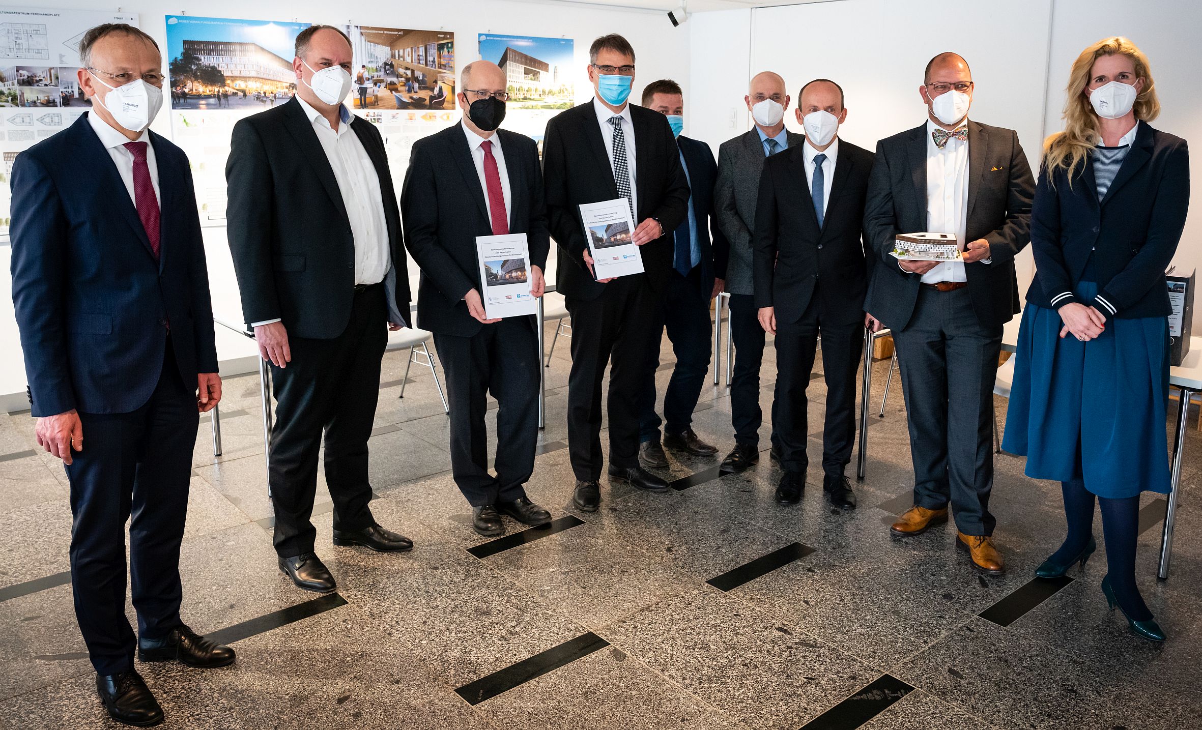 Foto von mehreren, stehenden Personen, die Coronamasken tragen