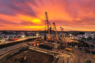 Construction site with cranes at sunset