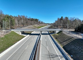 Bahnbrücke, die über eine Autobahn führt