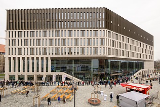 Bild eines neuen Gebäudes mit einer Glasfront vorne rechts