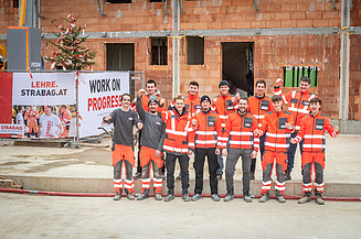 Foto von zwölf STRABAG Lehrlingen, die ein Haus errichteten