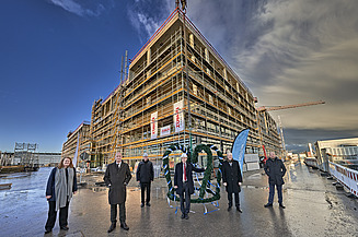Foto von mehreren Personen die vorm Richtkranz stehen über dem LabCampus am Flughafen München.