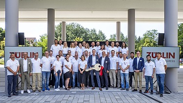 Foto von mehreren Personen zur feierlichen Schlüsselübergabe für hochmodernen Bürogebäude in Nürnberg. 