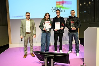 Foto von vier Personen auf einer Bühne. 