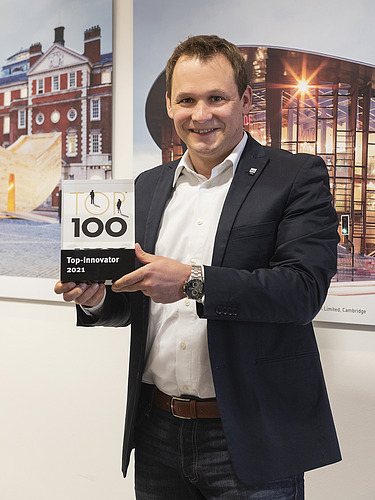 Foto von Andreas Amorth mit dem Preis Top100. 