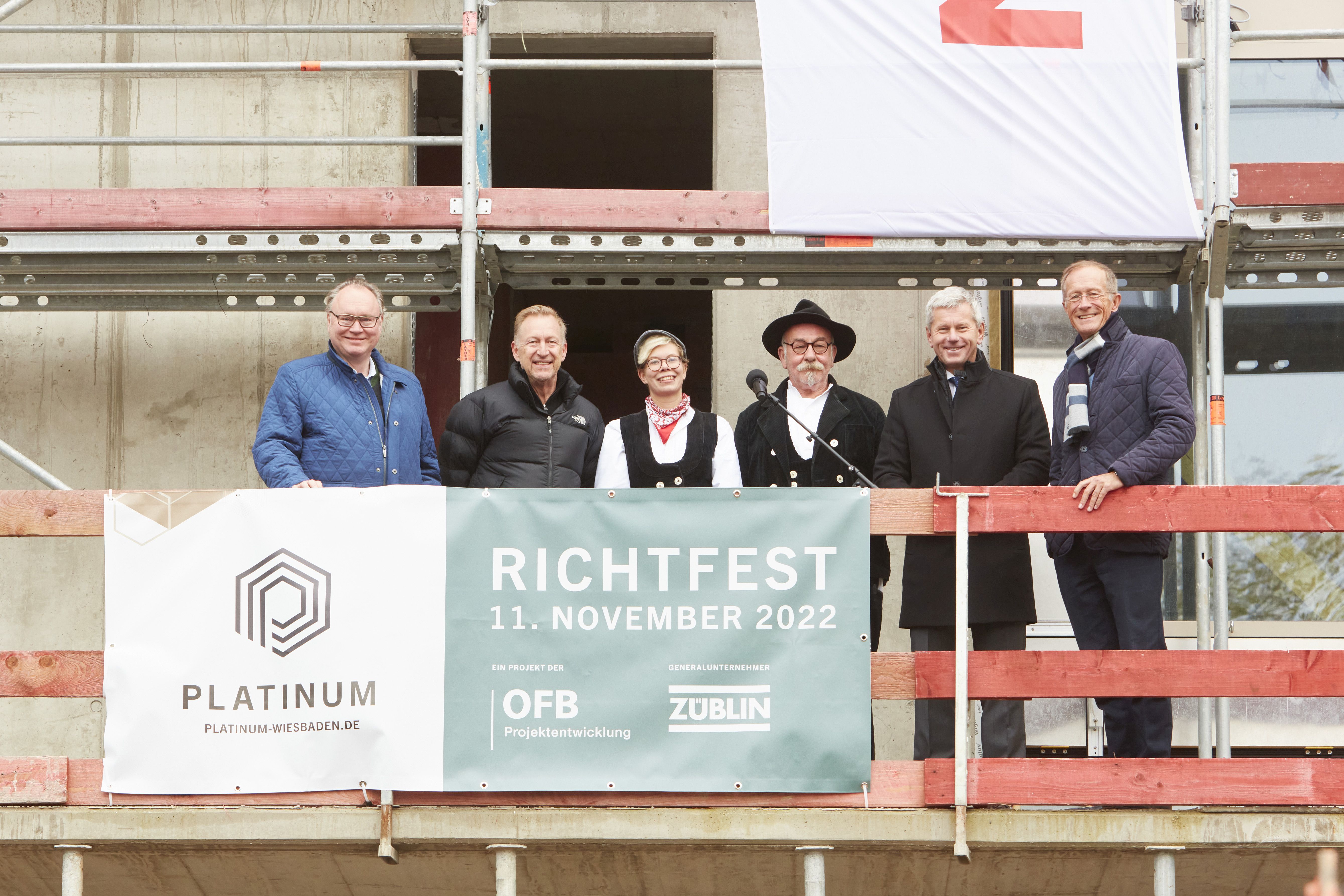 Foto von mehreren Personen auf einem Gerüst, beim Richtspruch. 