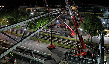Foto von einer Brücke die grade gebaut wird aus der Vogelperspektive bei Nacht. 